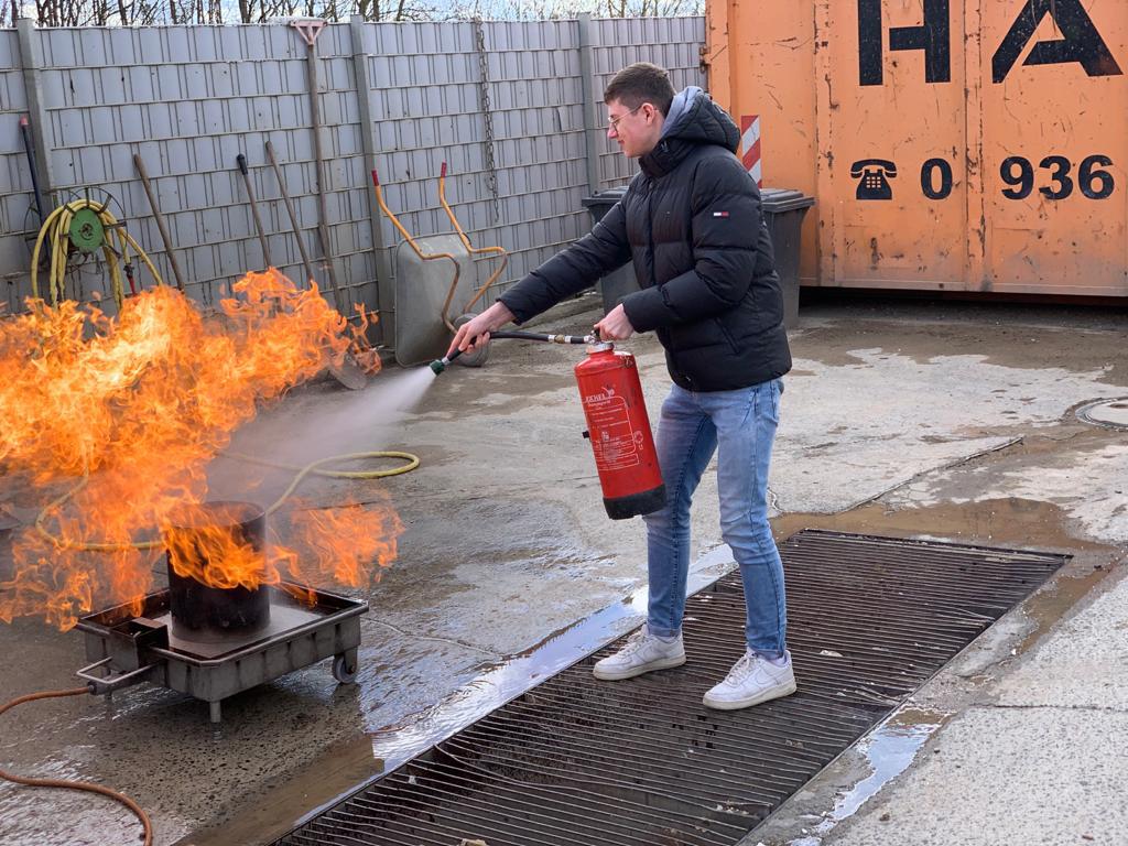 Mitarbeiter löscht Feuer